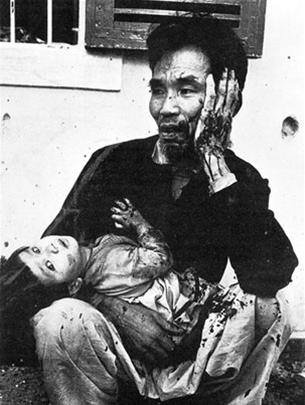 Hai cha con cùng bị thương tích, áo quần đẫm máu - Ảnh: Vietnam Bilder eines Krieges (Đức)