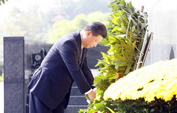 Tập Cận Bình chỉnh lại ruy băng trên vòng hoa viếng Bác Hồ