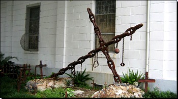 The Tomb of the Unknown Slave is located in the garden plot of Saint Augustine Church. This shrine, consisting of grave crosses, chains and shackles is dedicated to the memory of the nameless, faceless, turfless Africans who met an untimely death in Faubourg Treme